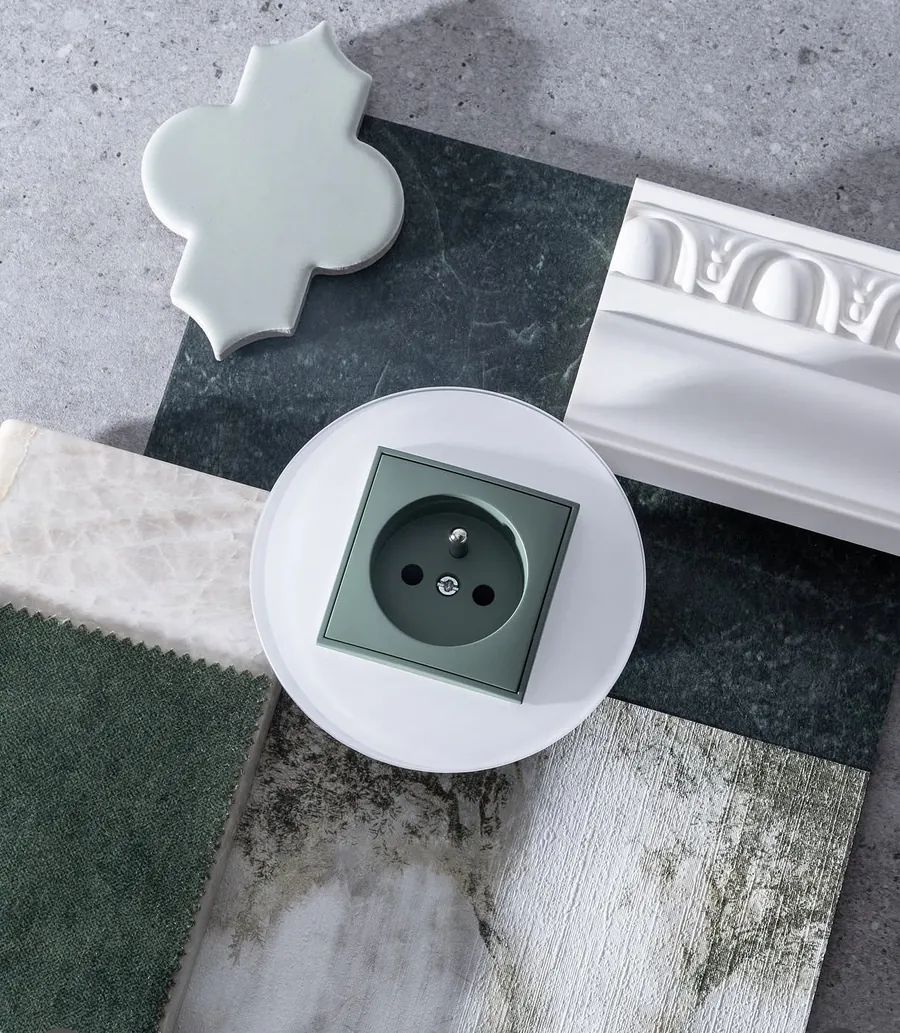 Karlik Icon sage green socket with round white frame on materials moodboard