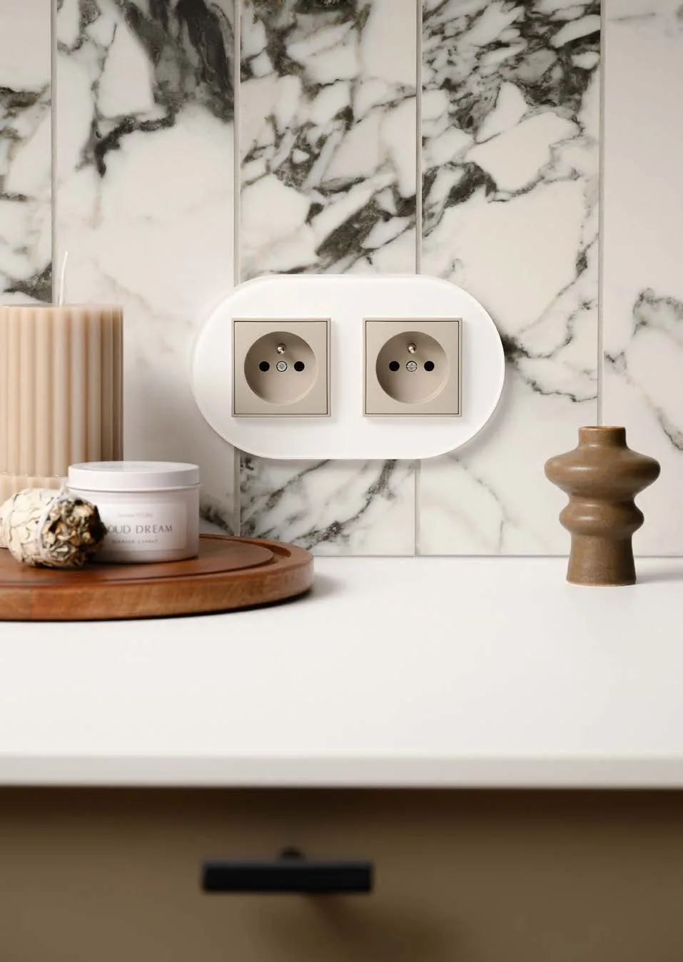 Karlik ICON white round glass-effect frame with double socket on a marble wall